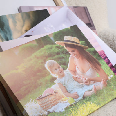 Stack of personalised canvas photo prints including family portraits ready for professional canvas stretching and display